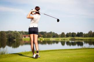 Woman golfing in mid-swing