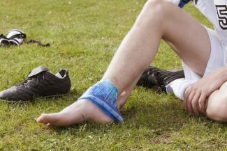 Young soccer player icing their ankle