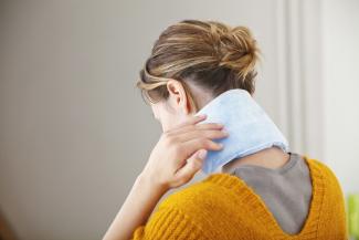 Woman applying ice pack to her neck